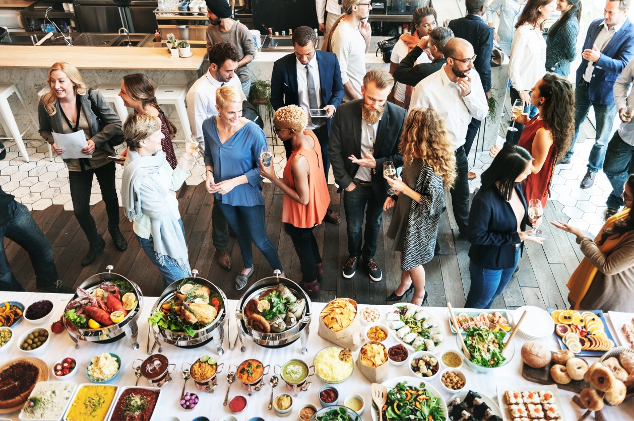 Catered event for businesses - Business people eating and drinking during a catered event.